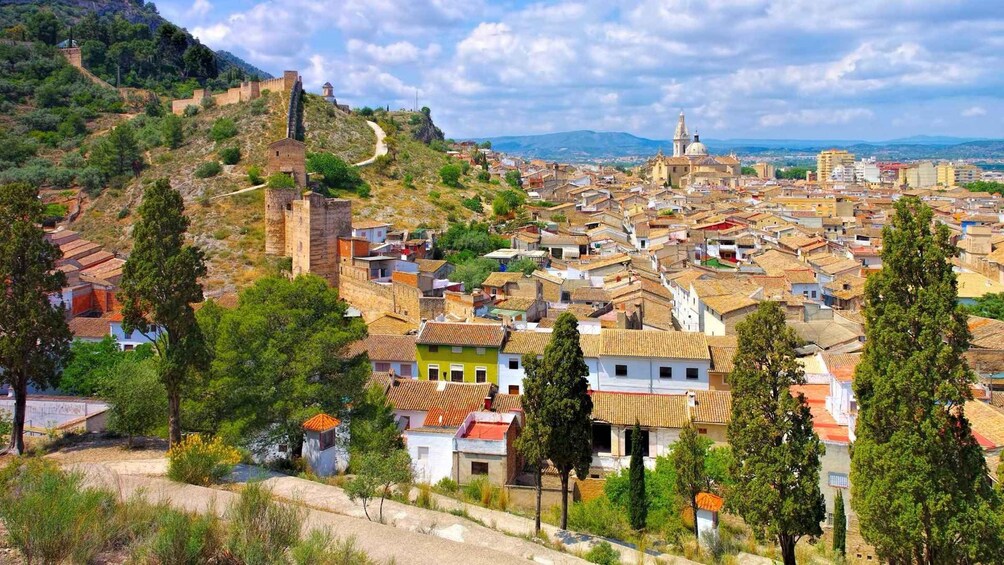 A town with a historic fortification on a hill, colorful houses, and a prominent church. 3