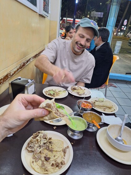 Henkilö syö tacosta ravintolassa. 4