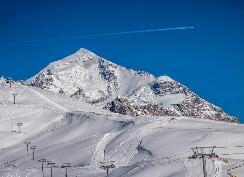 A snow-covered mountain with ski lifts and tracks. 4