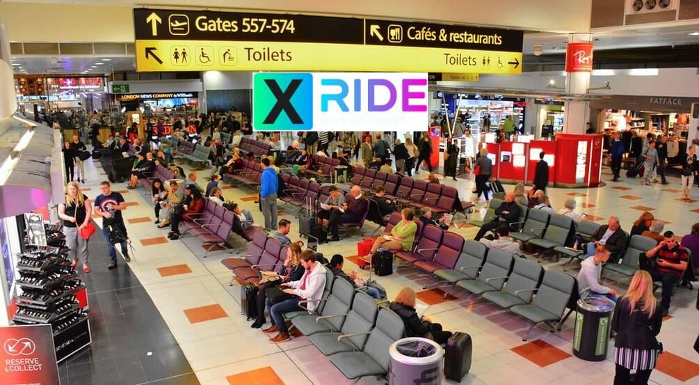 Vilkkaassa lentokentän terminaalissa on istuinalueita, opasteita eri lähtöporteille ja selvästi näkyvässä paikassa oleva mainos, jossa lukee »X RIDE». 2