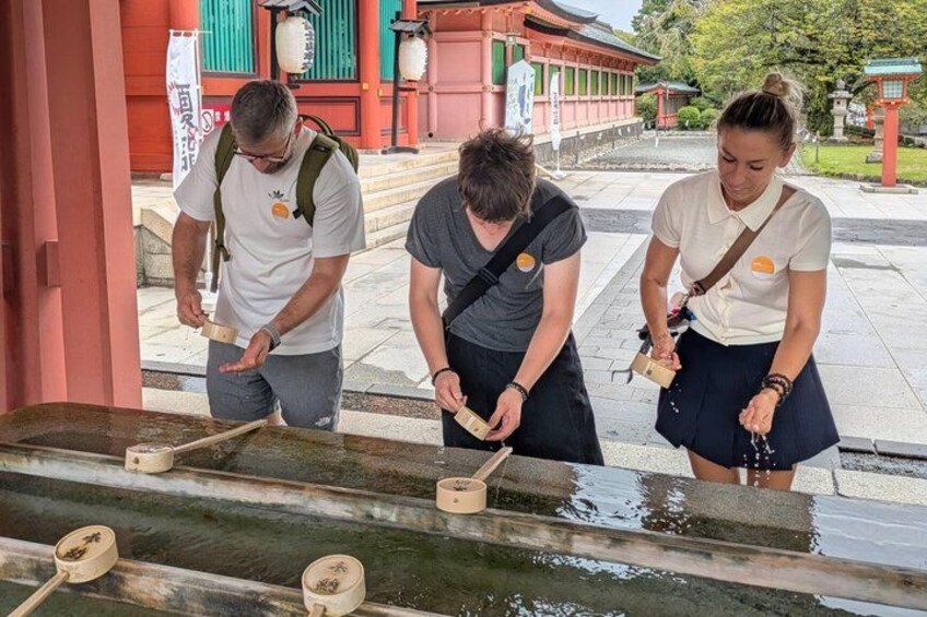 Three people pouring sake into a wooden barrel. 4