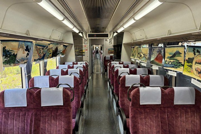 A train interior with rows of seats and artwork on the walls. 4