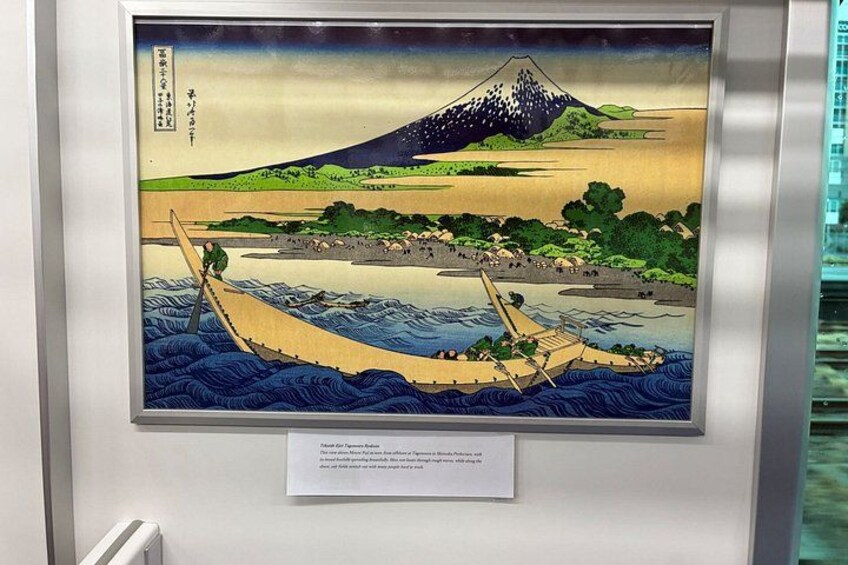 A framed Japanese woodblock print of Mount Fuji, a river, and a traditional boat. 5