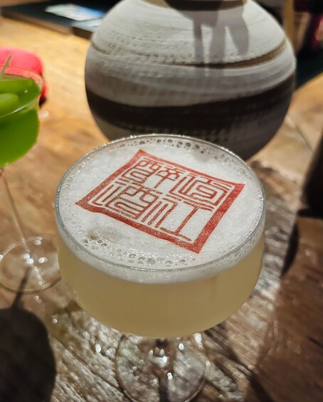 Lasi, jossa on kuohuvaa juomaa, ja lasin pinnalla on logo. 4