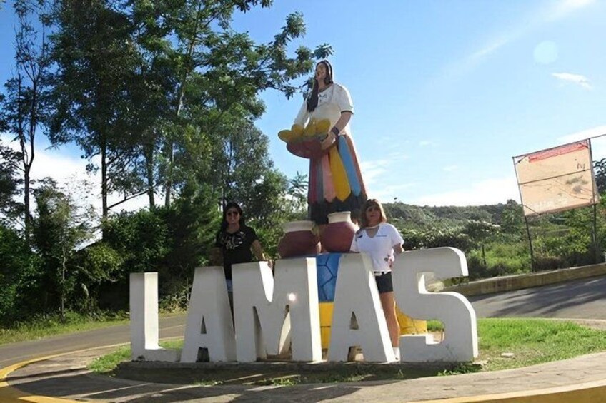 A large sign with the word 'LAMIAS' and a colorful statue of a woman. 1