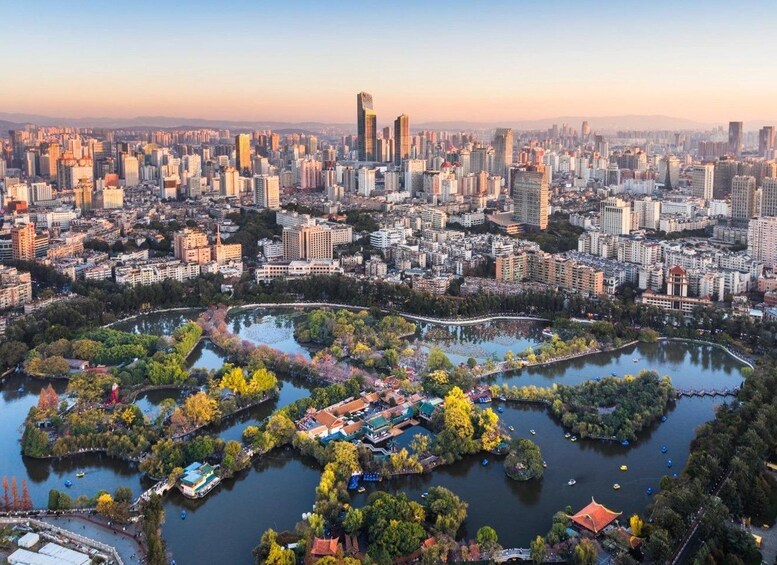 Een stadsbeeld met een dichte verzameling wolkenkrabbers en een centraal park met waterpartijen en bomen. 1