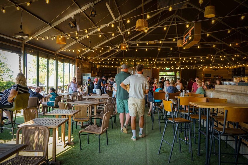 An outdoor dining area with tables and chairs, string lights, and a bar. 5