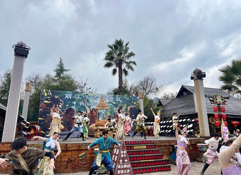 A cultural performance with dancers in traditional costumes on a stage with a backdrop. 2