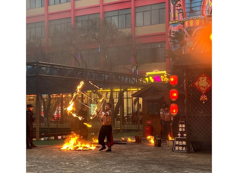 A fire performance in front of a building with a neon sign. 4