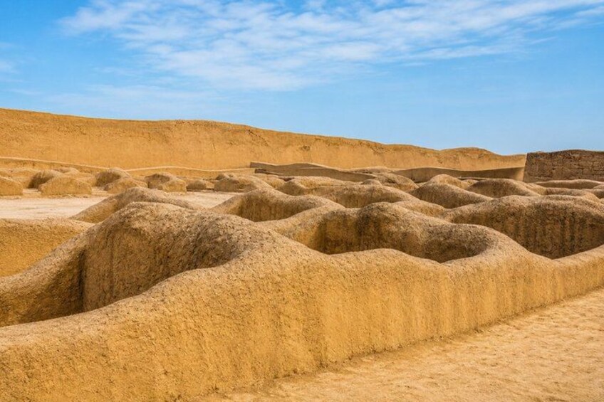 A desert landscape with undulating sand dunes and a clear sky. 2