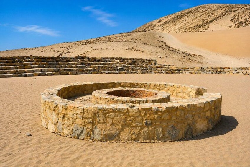A stone structure in a desert with a clear sky. 5