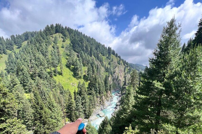 A river winding through a forested mountain landscape. 4