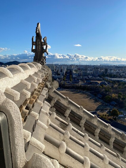 A cityscape with a prominent statue on a hill, a clear sky, and a distant mountain range. 2