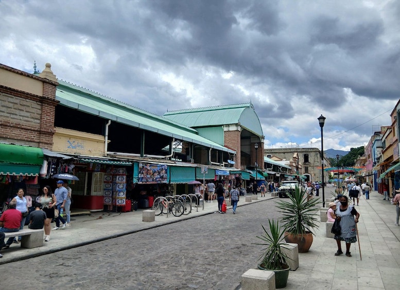 A bustling street with shops, a green-roofed building, and people walking. 2