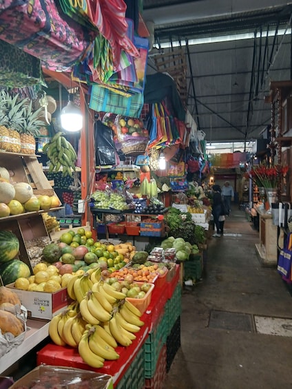 A bustling indoor market with various fruits and vegetables on display. 4