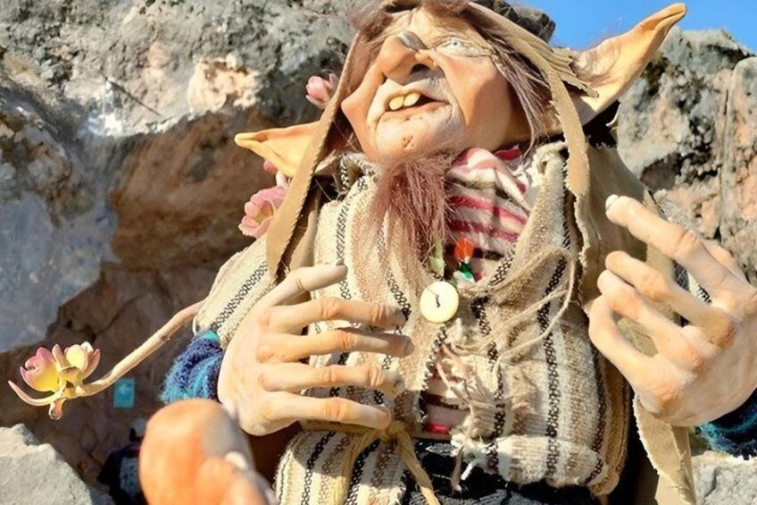A person in a costume with a beard, holding a flower. 1