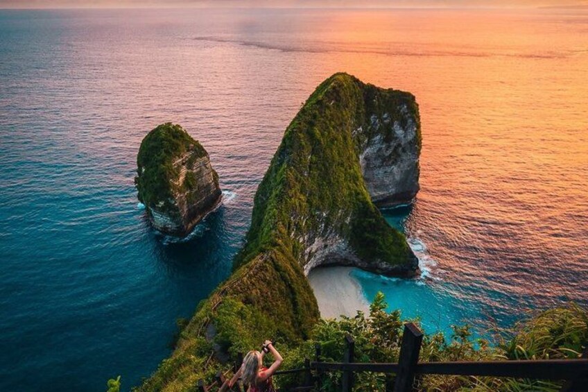 A coastal landscape with three prominent rock formations surrounded by turquoise waters. 1