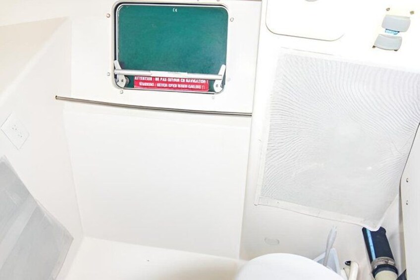 A bathroom with a green-tinted window, a white sink, and a towel rack. 4