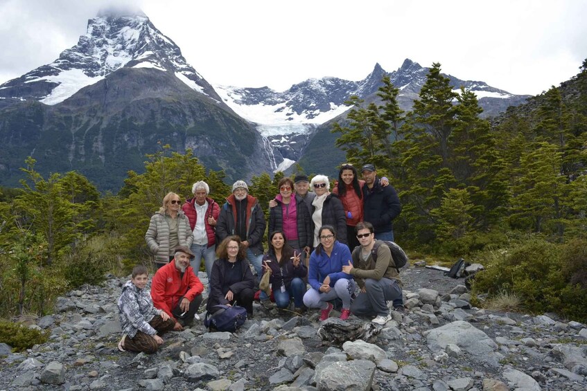 A group of people posing in a mountainous area with snow-capped peaks in the background. 5