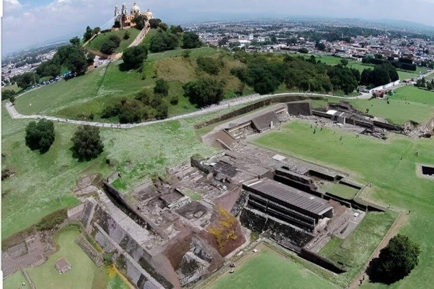 An ancient archaeological site with ruins and a hilltop structure. 3