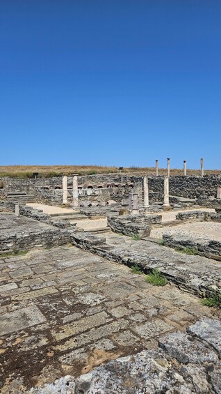 Ancient ruins with stone columns and a clear blue sky. 5