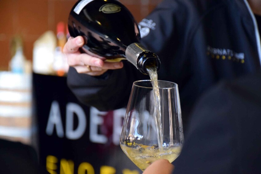 A person pouring a liquid from a bottle into a glass. 2