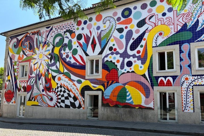 A colorful mural on a building with abstract patterns and shapes. 3