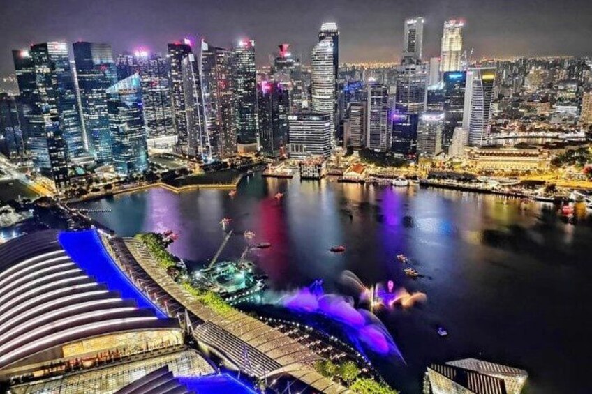 A city skyline with illuminated buildings, a waterfront, and a large stadium. 3
