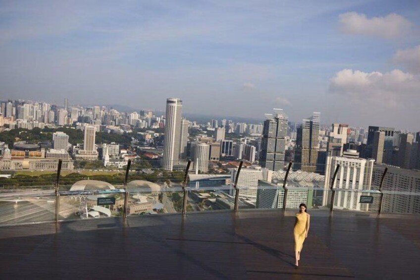 A cityscape with high-rise buildings, a bridge, and a person walking on a platform. 4