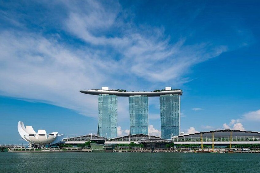 A modern architectural structure with two prominent towers, a waterfront, and a unique white sculpture. 1