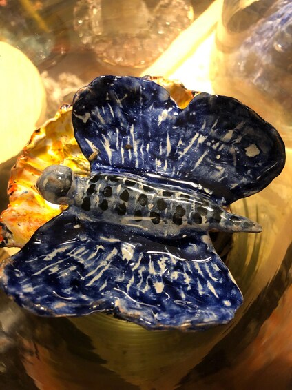 A ceramic turtle sculpture with blue and white patterns, placed on a table with other decorative items. 5