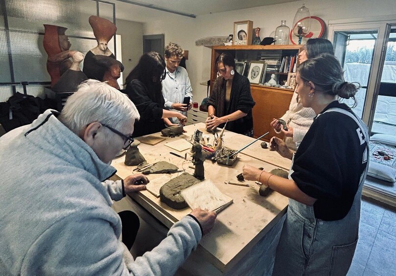 A group of people engaged in pottery making at a workshop. 3