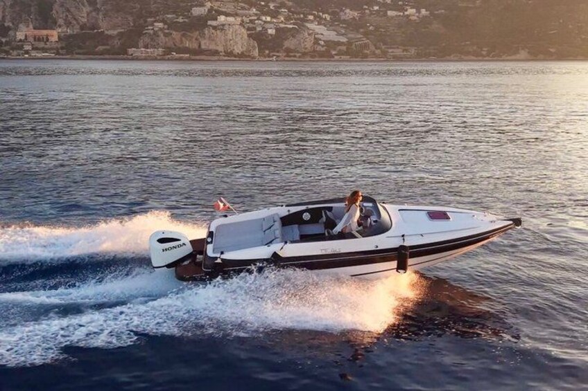 Una lancha blanca con el logotipo de Honda en la parte trasera, navegando sobre aguas tranquilas con un litoral rocoso al fondo. 4