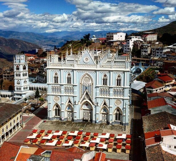 A cathedral with intricate Gothic architecture, surrounded by a town with red-roofed buildings. 2