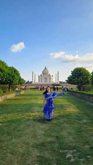 Eine Person in einem blauen Kleid geht auf den Taj Mahal zu. 2