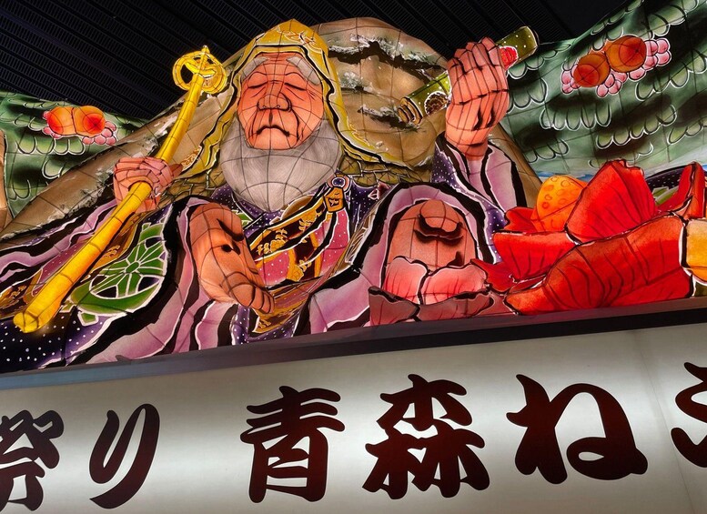 A colorful mural with a figure holding a staff and a scroll, and Japanese characters below. 5