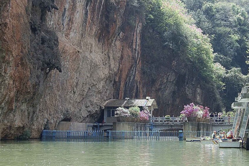 A rocky cliff, a small building with a roof, and a bridge over water. 5