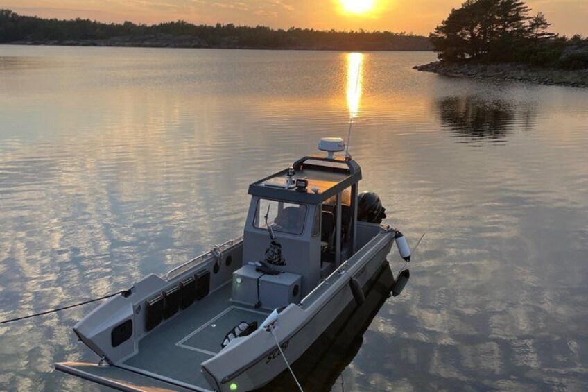 A small boat on calm water with a sunset in the background. 2