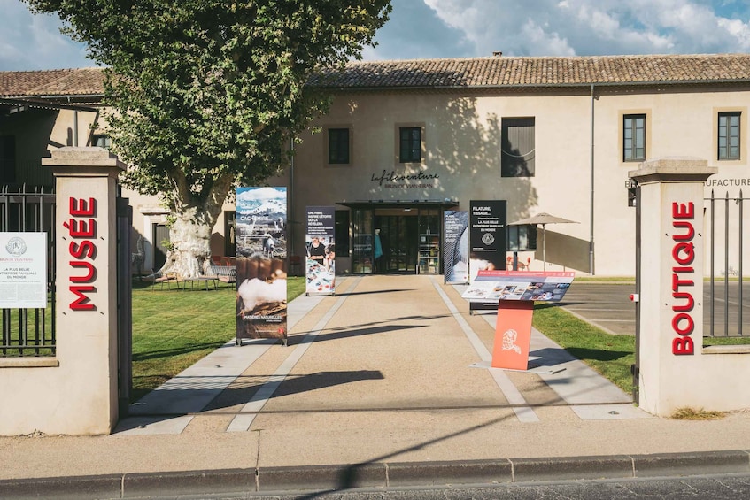 A building entrance with a sign reading 'MUSÉE' and 'BOUTIQUE' on either side. 1