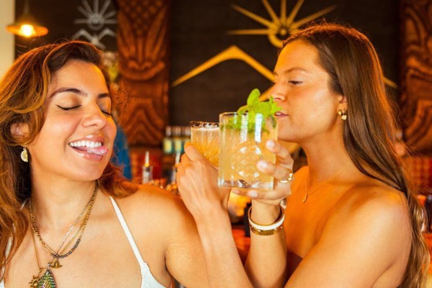 Two people holding drinks in a bar with wooden decor and a star-shaped light fixture. 5