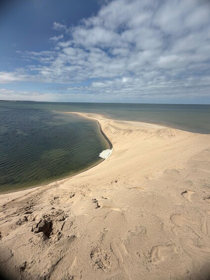 A sandy beach with footprints and a clear blue sky. 3