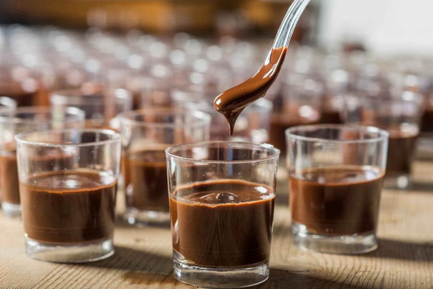 A spoon pouring chocolate into a glass. 1