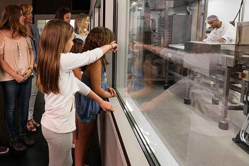 A group of people observing a chef at work in a kitchen. 5