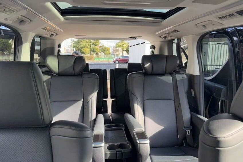 Interior de coche con techo solar, asientos de cuero y consola central. 3