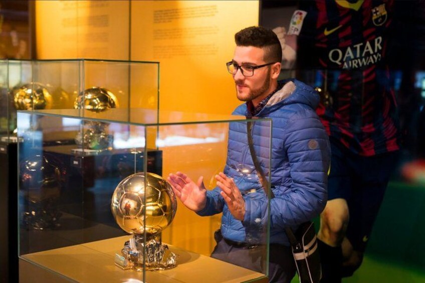 A person standing in front of a display case with a golden trophy. 3