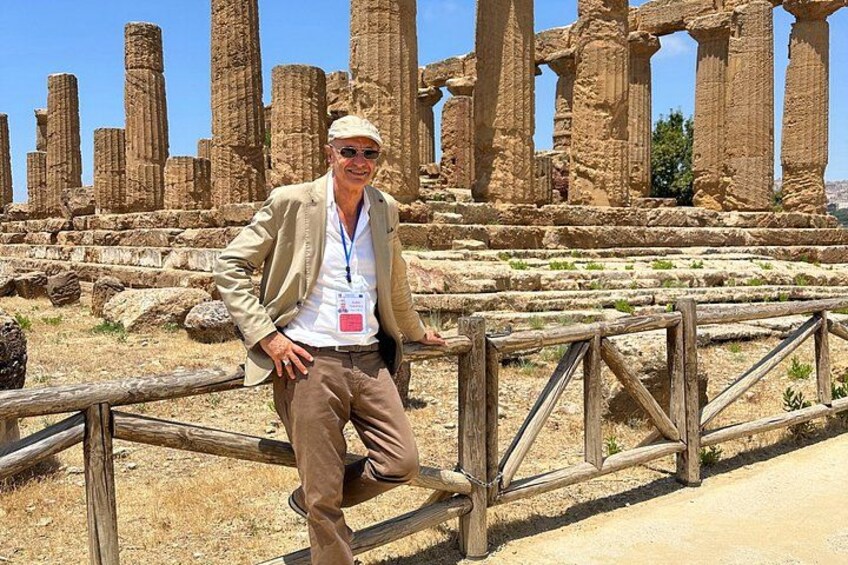 A person standing in front of ancient ruins with columns. 5
