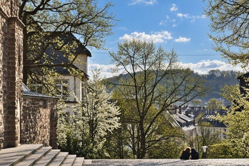 A stone building with steps, trees, and a mountain in the background. 3