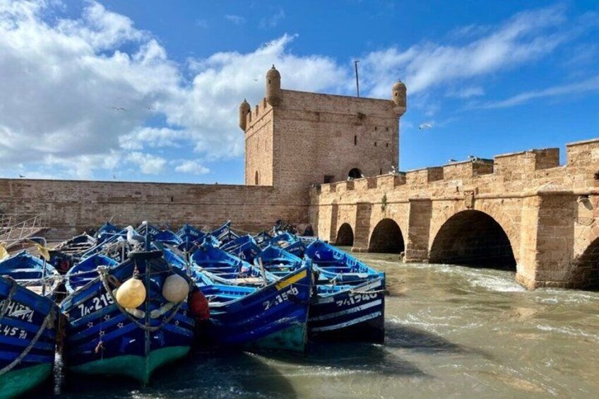 A historic stone bridge with boats docked in the water. 1