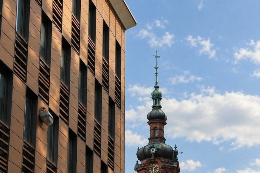 A modern building with vertical lines and a clock tower with a dome and cross. 5