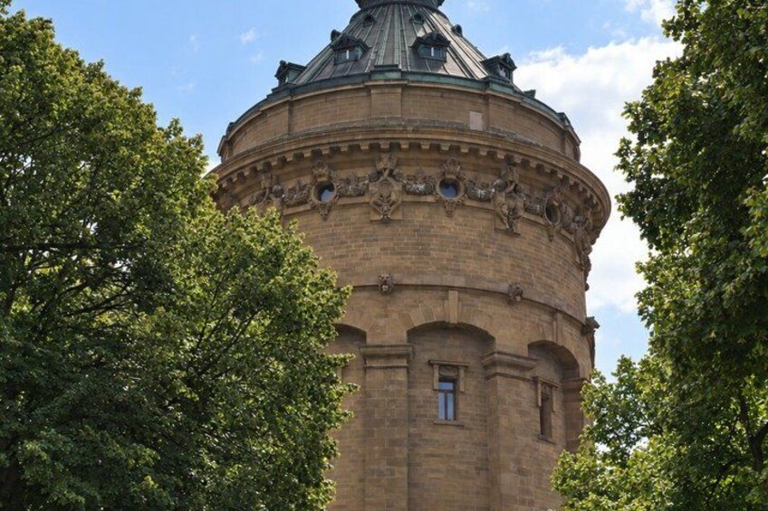 A round brick tower with a dome, surrounded by trees. 2